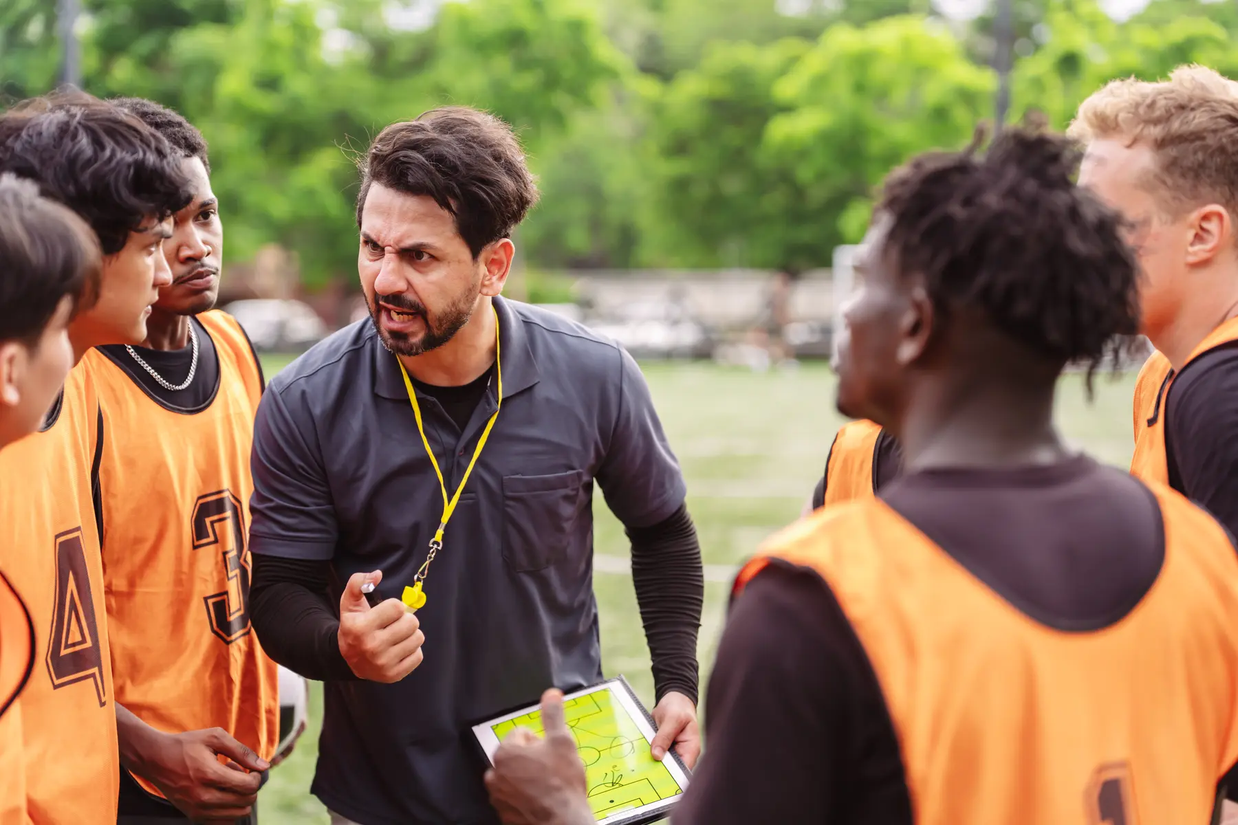 Coach discussing tactics with a football team